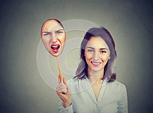 Happy woman taking off an angry mask of herself