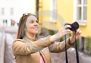 Happy woman taking photo with camera. Tourist on vacation.