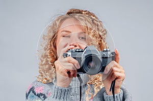 Cute woman taking a photo with a camera on a white background