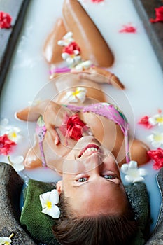 Happy woman taking pleasure in milk bath