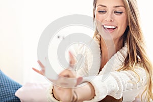 Happy woman taking selfie in bed