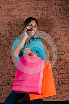 Happy woman talking on the phone with freshly made shopping bags