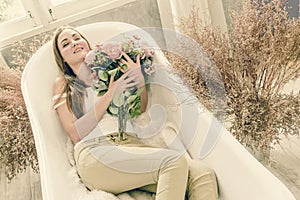 Happy woman teen lay in the bathtub with flower vintage