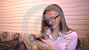 Happy woman texting, sending sms on smartphone in cafe. 4 k. Female professional using app on smartphone in cafe smiling