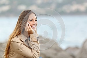 Happy woman thinking and looking away on the sea