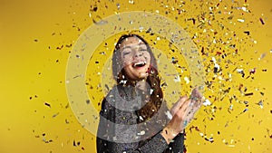 Happy woman throwing confetti enjoying party