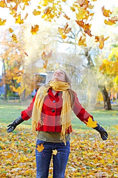 Happy woman throwing leaves