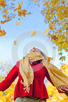 Happy woman throwing leaves.