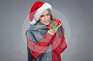 Happy woman with toothy smile wearing Christmas hat and holding