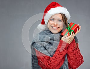 Happy woman with toothy smile wearing Christmas hat and holding