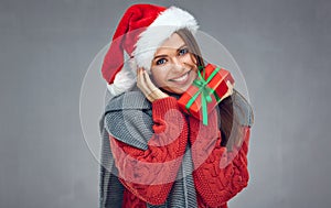 Happy woman with toothy smile wearing Christmas hat and holding