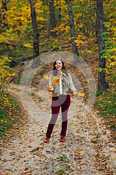 Happy woman toss up autumn leaves