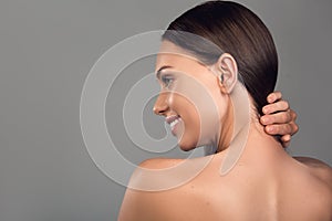 Happy woman touching bare neck