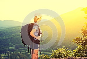 Happy woman tourist with a backpack on nature