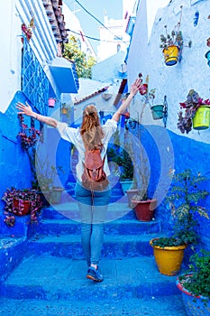 Happy woman tourist in the blue street of Chefchaouen