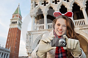 Happy woman tourist with camera on Christmas in Venice, Italy