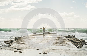 Happy woman tourist enjoying waves of stormy Mediterranean sea