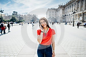 Happy woman tourist in front of Cathedral Santa Maria la Real de La Almudena in Madrid,Spain.Tourist using vacation sim card