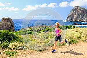 Happy woman trail running in beautiful mountains