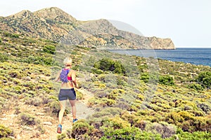 Happy woman trail running in beautiful mountains