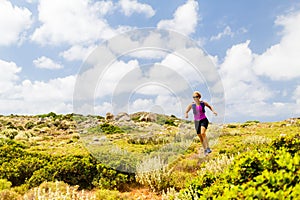 Happy woman trail running in inspirational mountain landscape