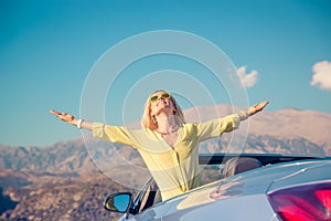 Happy woman travel by car in the mountains