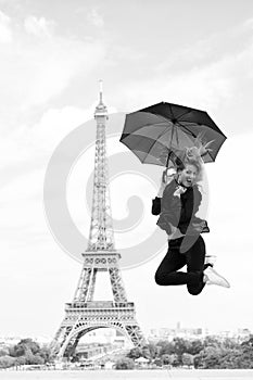Happy woman travel in paris, france. Woman jump with fashion umbrella. Girl with beauty look at eiffel tower. Parisian