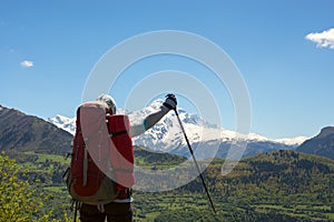 Happy woman traveler with open arms stands on the mountain plate