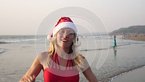 Happy woman on a tropical beach celebrates Christmas or New Year