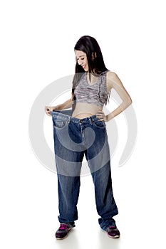 Happy woman trying her old jeans on studio