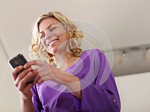 Happy woman typing text message on mobile phone