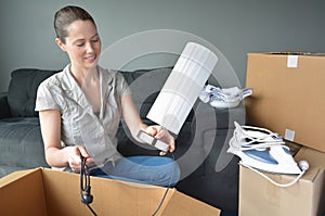 Happy woman unpack boxes during a move into a new home