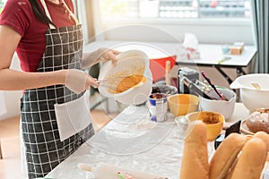 Happy woman use fresh natural products flour milk eggs kneading dough for pastries cookies by hands at modern kitchen