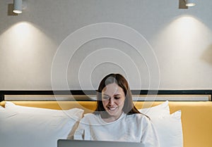 Happy Woman Using Laptop in Comfortable Bedroom
