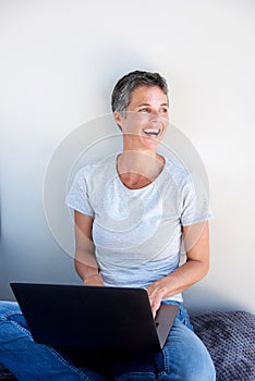 Happy woman using laptop computer and looking away