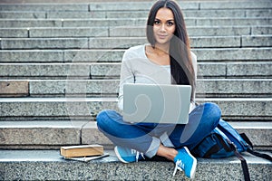 Happy woman using laptop computer outdoors