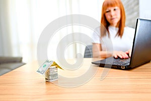 Happy woman using laptop. Concept of buying a home, real estate activity, meeting with advisor, new homes.