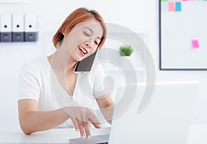 Happy woman using mobile phone and laptops for work