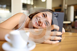 Happy woman using phone in a restaurant