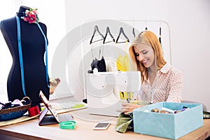 Happy woman using a sewing machine