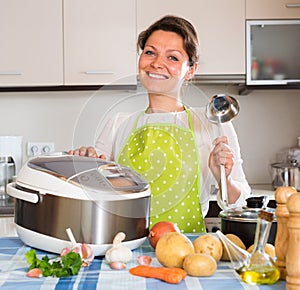 Happy woman using slo-cooker