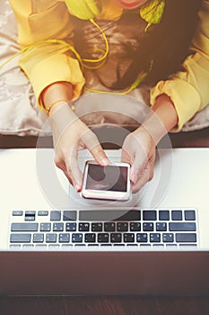 Happy woman using smart phone and laptop computer. Vintage tone.