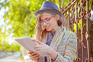 Happy woman using tablet computer outdoors