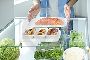 Happy Woman With Vegetables In Front Of Open Refrigerator