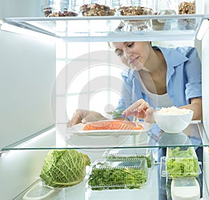 Happy Woman With Vegetables In Front Of Open Refrigerator