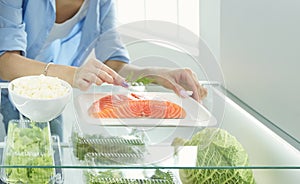 Happy Woman With Vegetables In Front Of Open Refrigerator