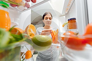 Happy Woman With Vegetables In Front Of Open Refrigerator. concept of healthy eating at home