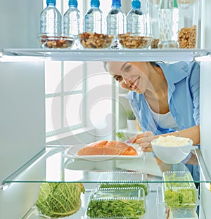 Happy Woman With Vegetables In Front Of Open Refrigerator, selective focus