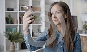 Happy woman on video chat with phone at home