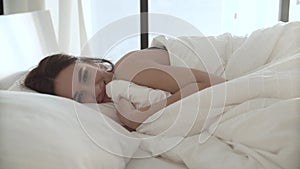 Happy Woman Waking Up In Comfortable Bed With White Linens